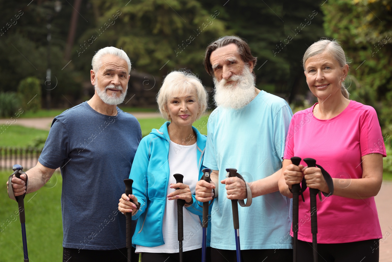 Photo of Group of senior people with Nordic walking poles outdoors