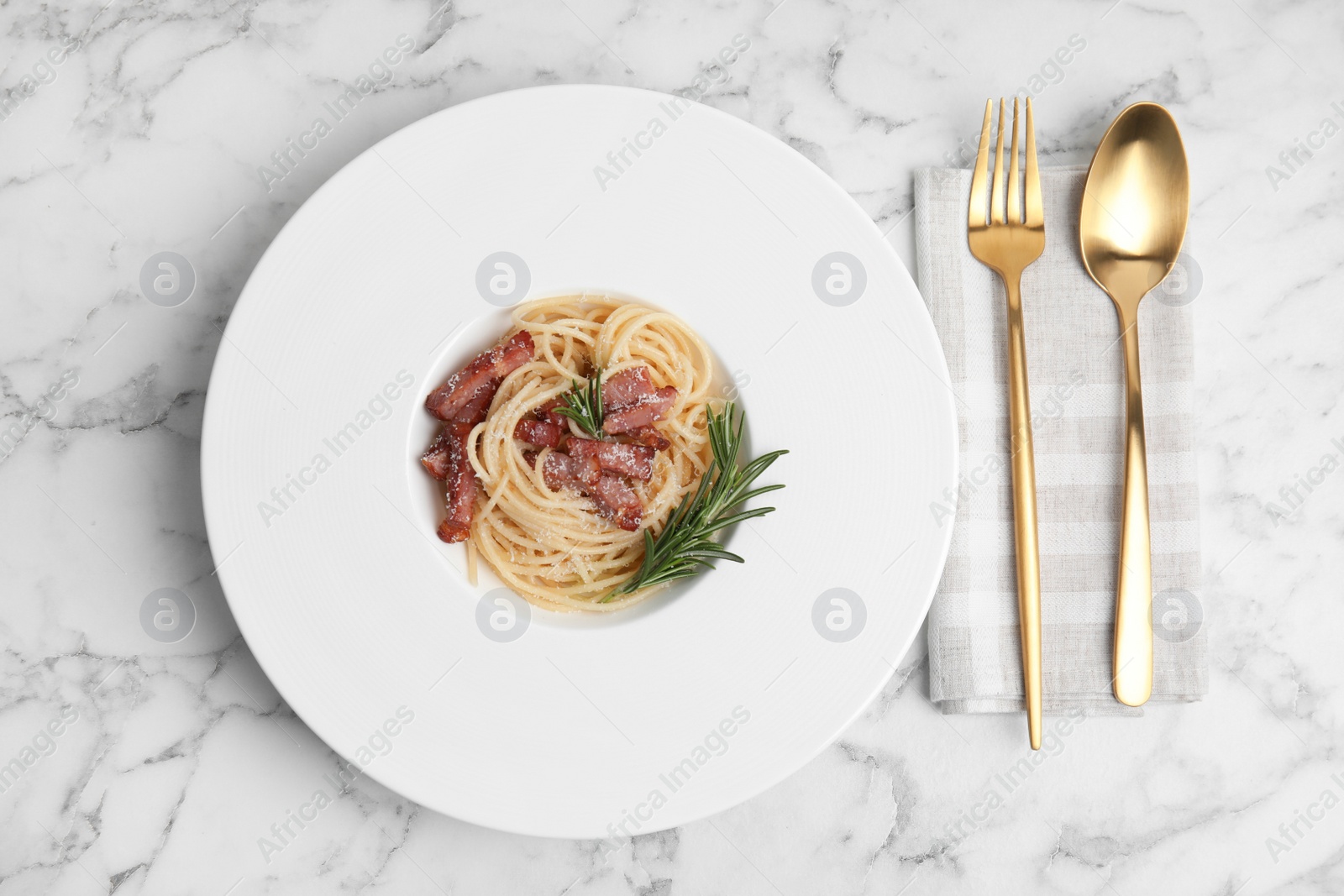 Photo of Delicious Carbonara pasta served on white marble table, flat lay