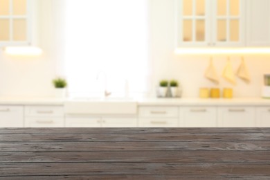 Empty wooden table and blurred view of stylish kitchen interior. Mockup for design