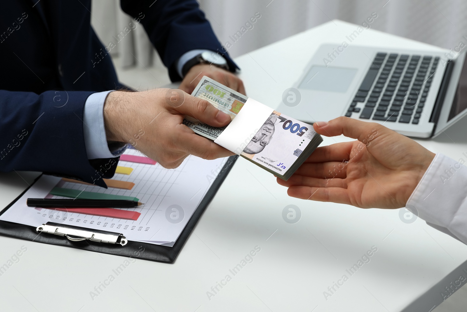 Image of Currency exchange. Man giving money to woman at table, closeup. Combined hryvnia and dollar banknote design