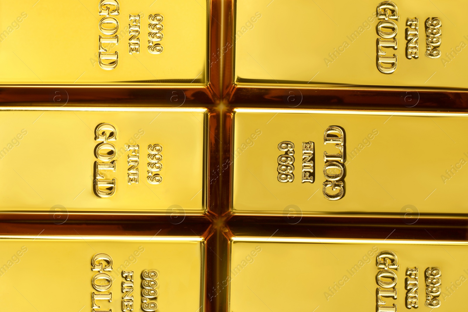 Photo of Many shiny gold bars as background, top view