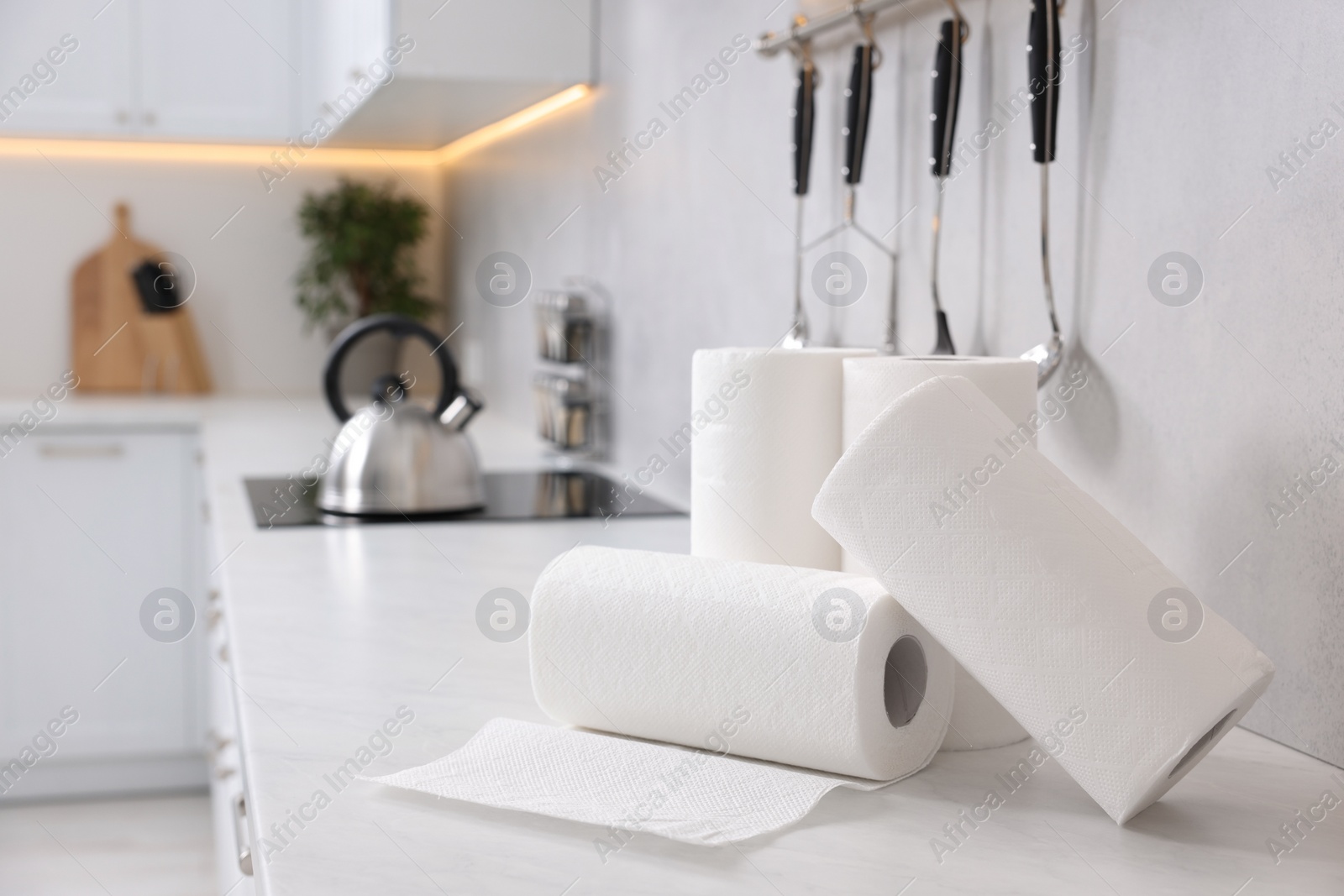 Photo of Rolls of paper towels on white countertop in kitchen. Space for text