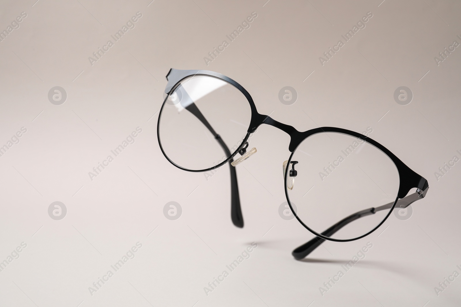 Photo of Stylish pair of glasses with black frame on beige background. Space for text