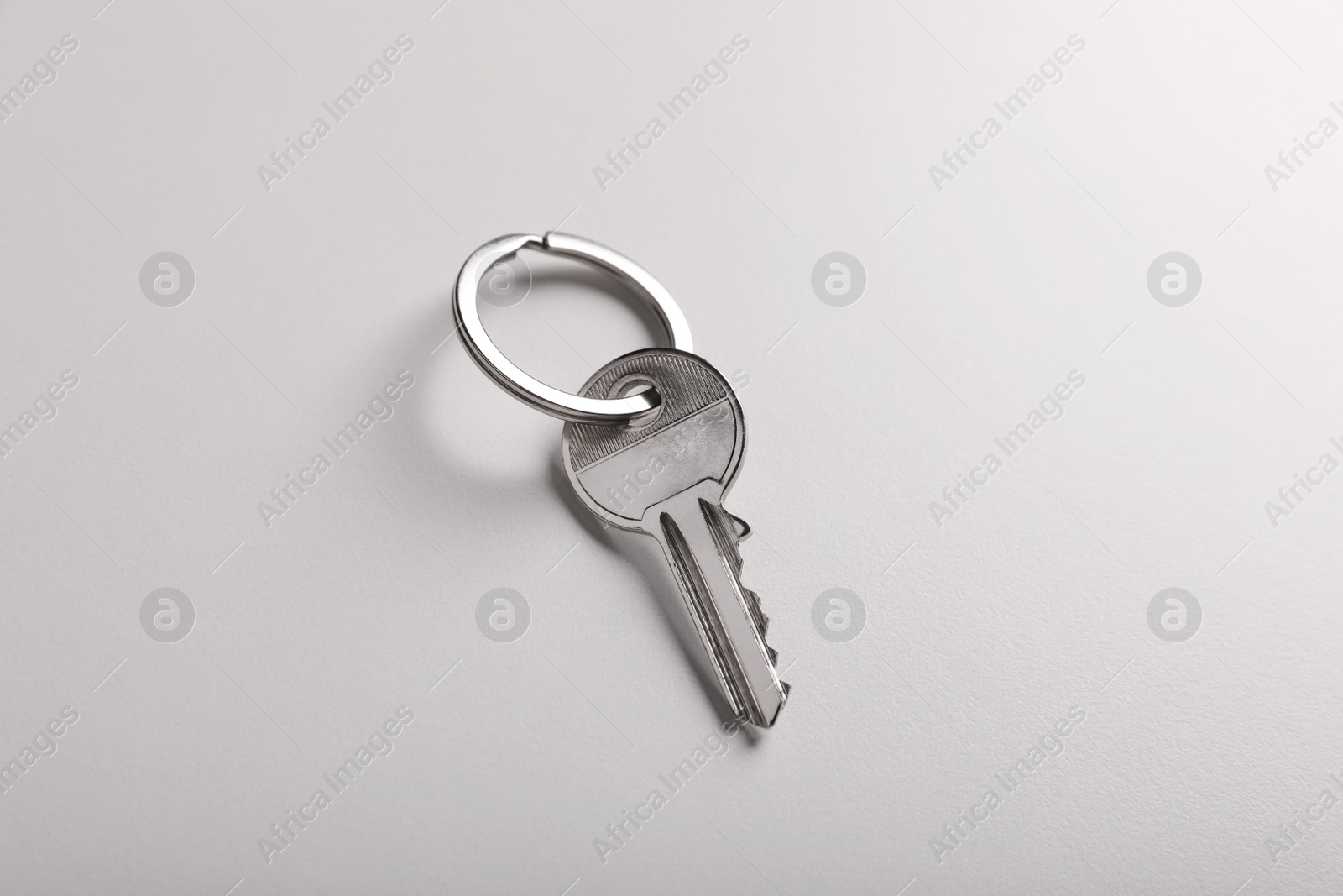 Photo of House key on light grey background. Real estate agent services
