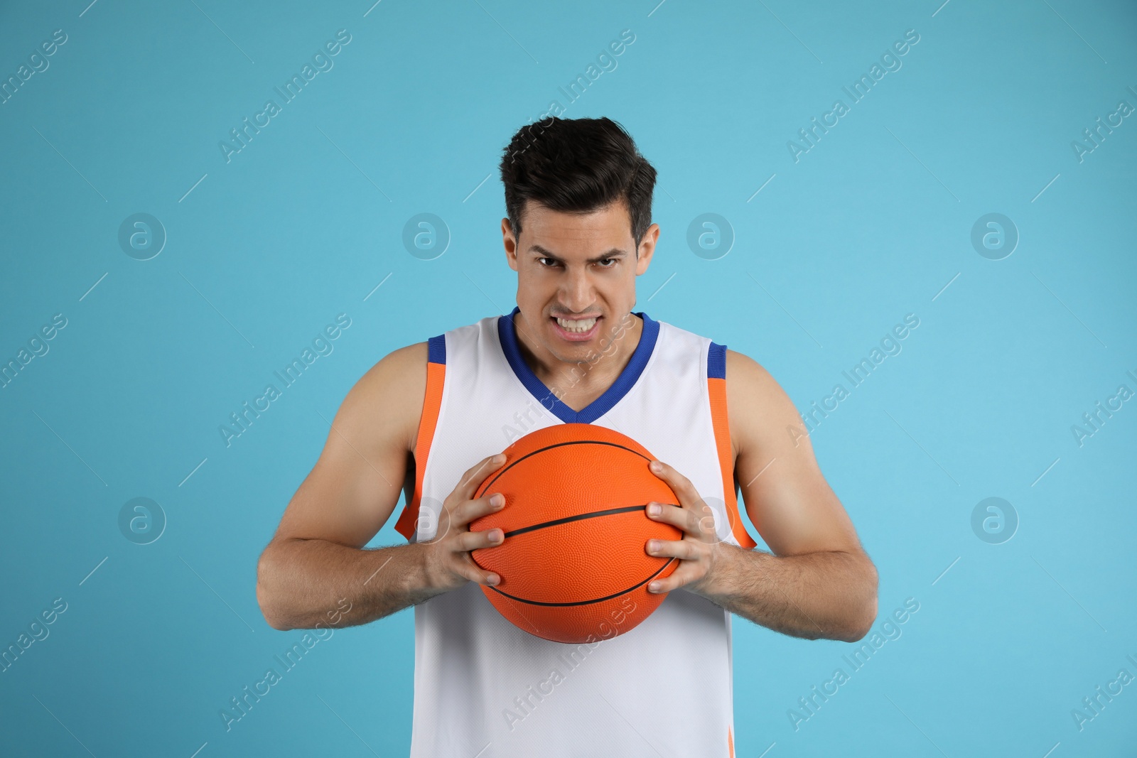 Photo of Basketball player with ball on light blue background