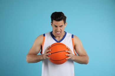 Basketball player with ball on light blue background
