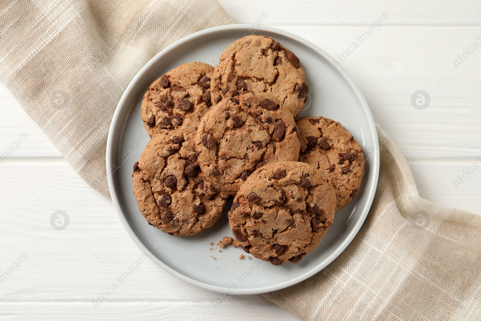 Photo of Delicious chocolate chip cookies on white wooden table, top view