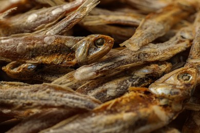 Many tasty dried anchovies as background, closeup