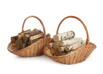 Photo of Wicker baskets with firewood on white background