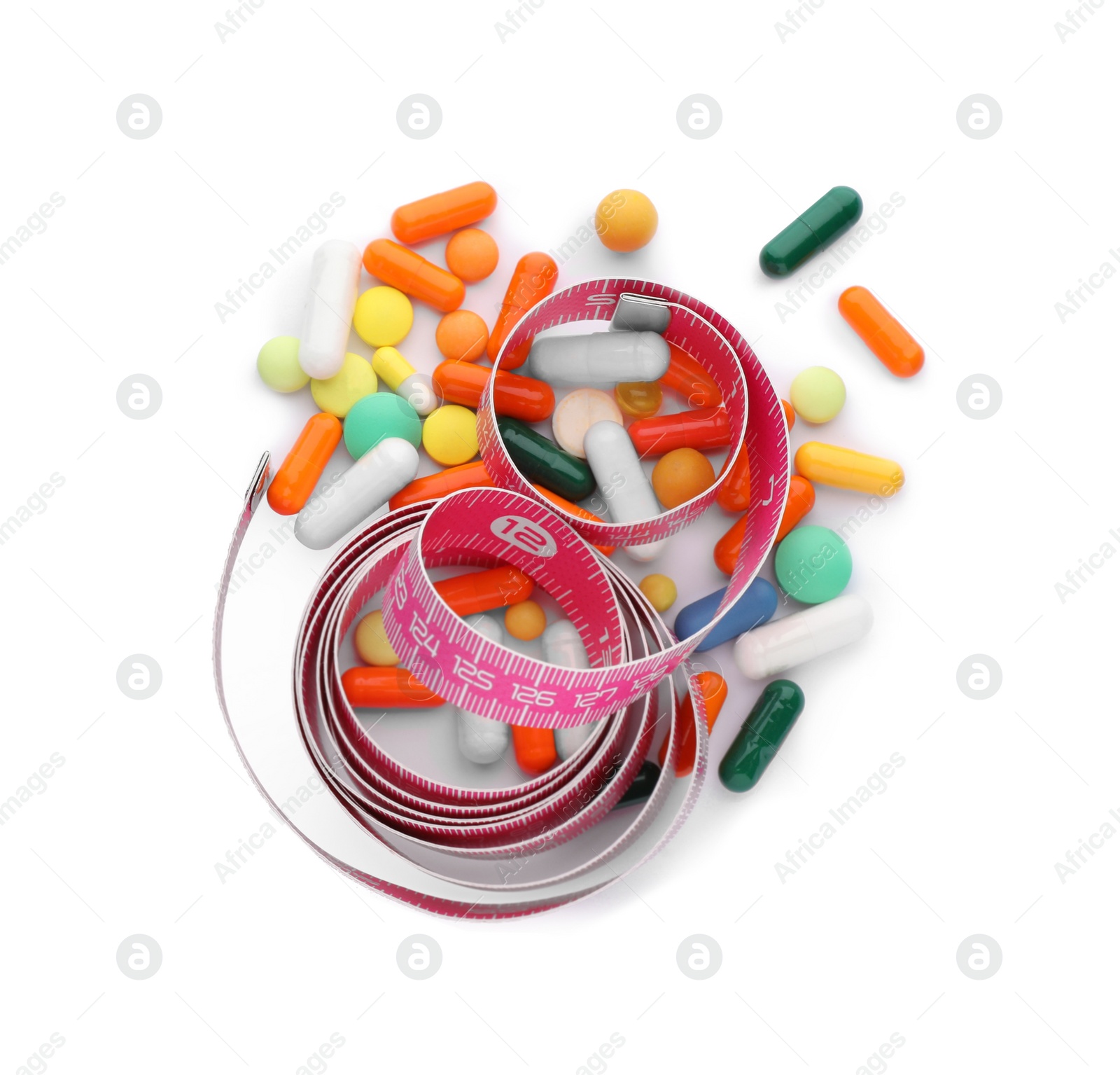 Photo of Many different weight loss pills and measuring tape on white background, top view