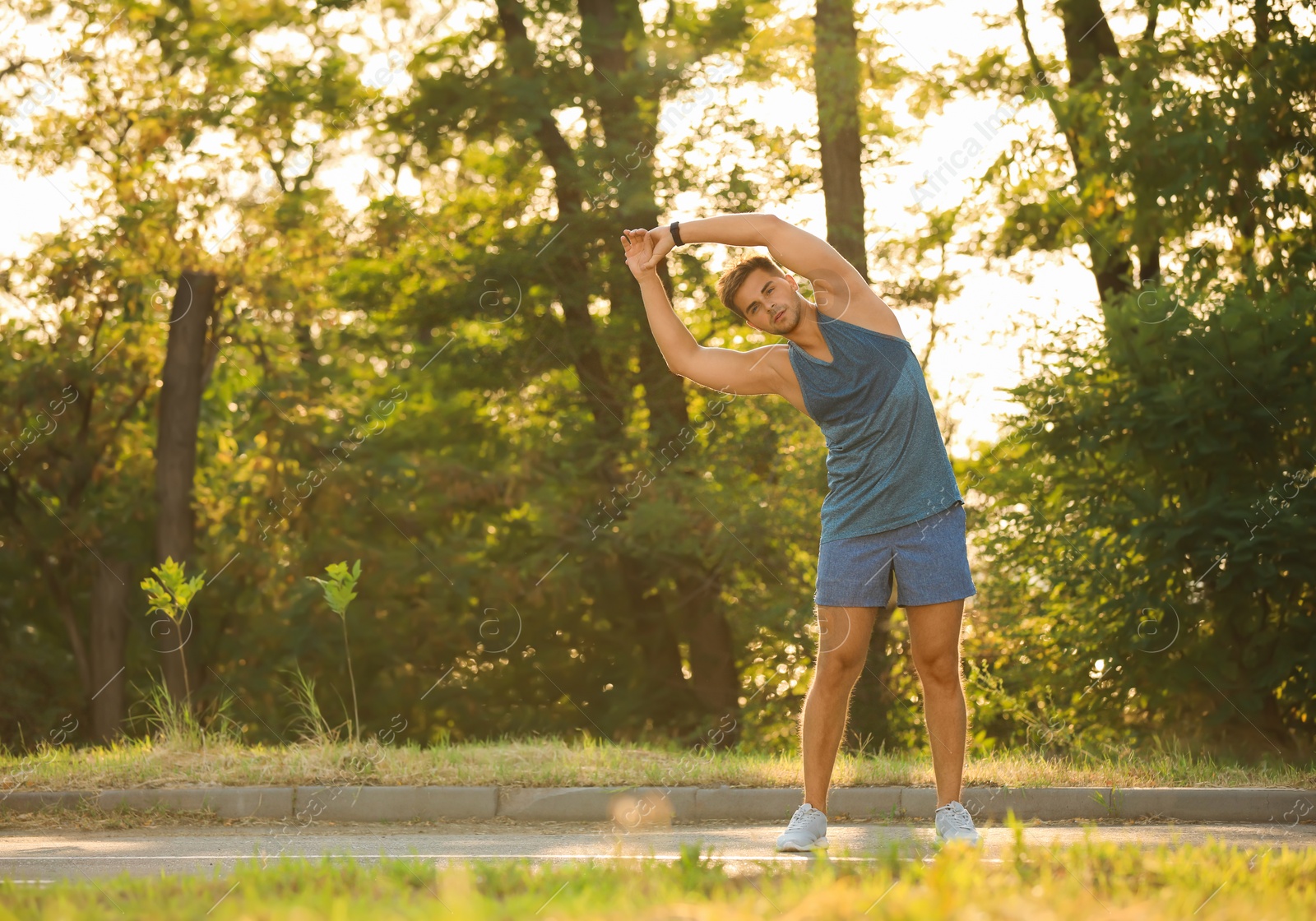 Photo of Young man doing exercise in park on sunny day