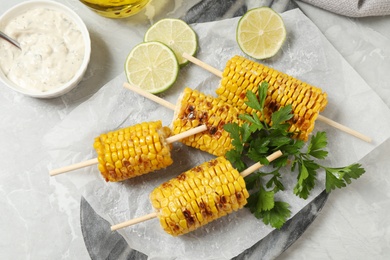 Photo of Flat lay composition with tasty grilled corn on table