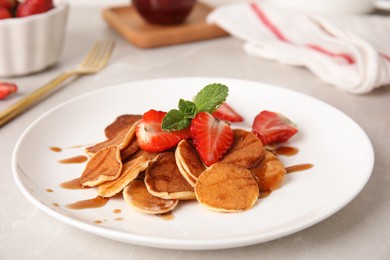 Photo of Cereal pancakes with strawberries on light grey marble table