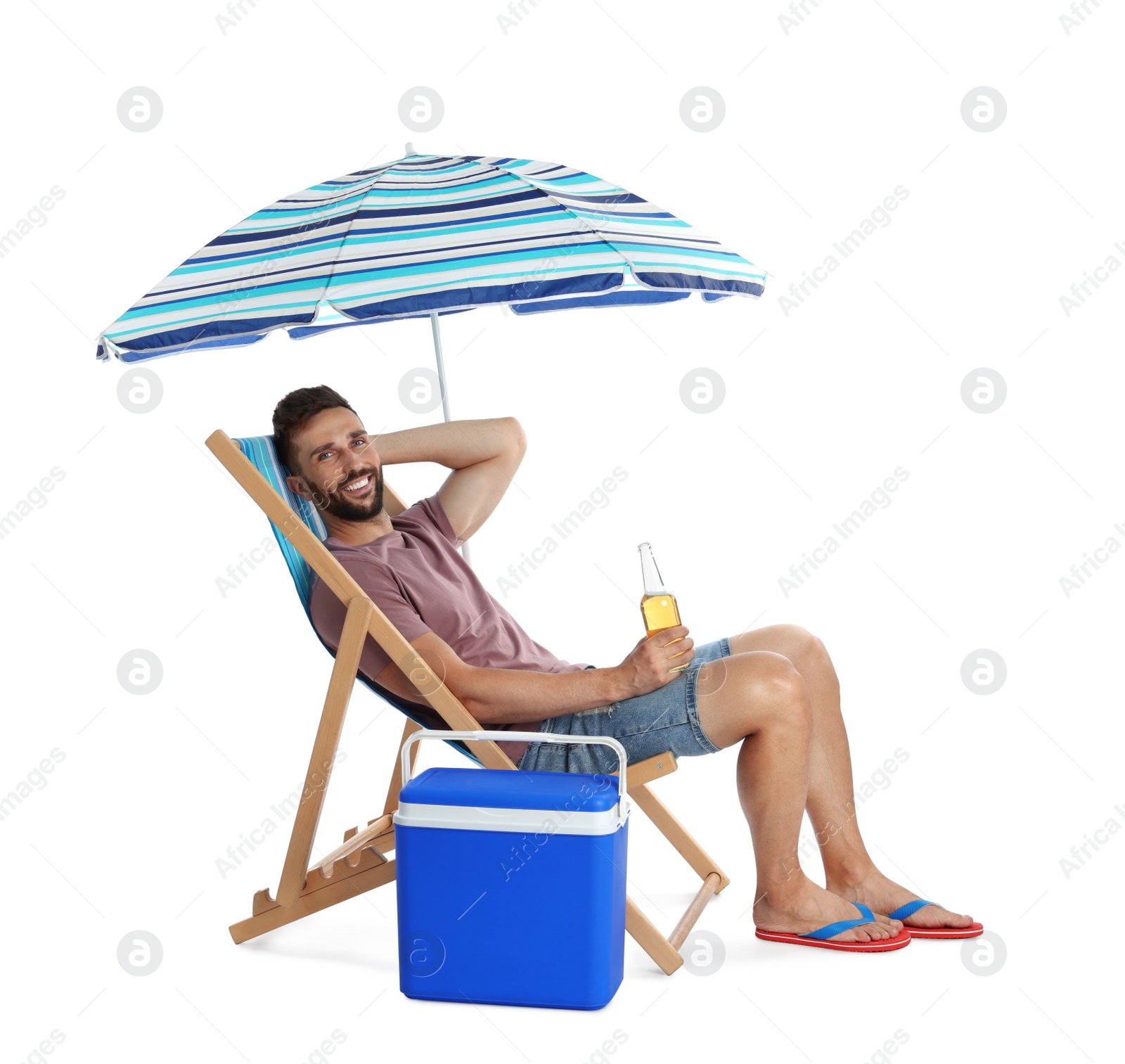 Photo of Happy man with bottle of beer resting in deck chair near cool box on white background