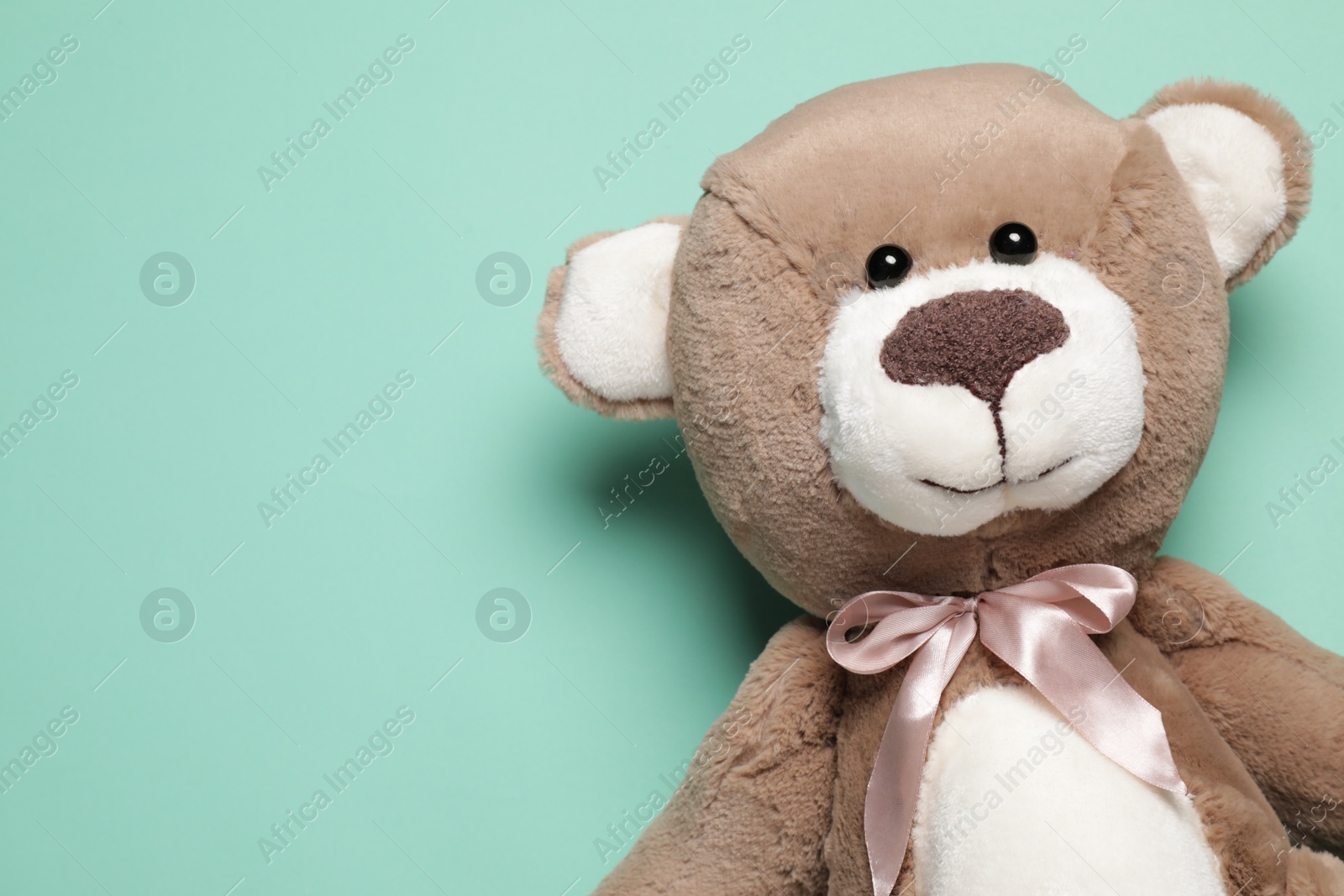 Photo of Cute teddy bear on turquoise background, top view. Space for text