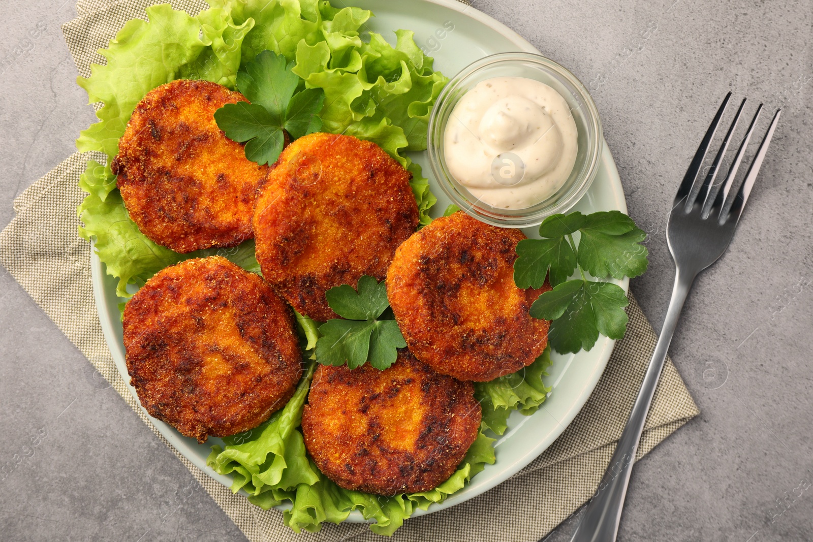 Photo of Tasty vegan cutlets served with sauce on light grey table, top view