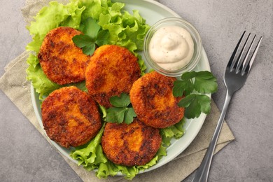 Tasty vegan cutlets served with sauce on light grey table, top view