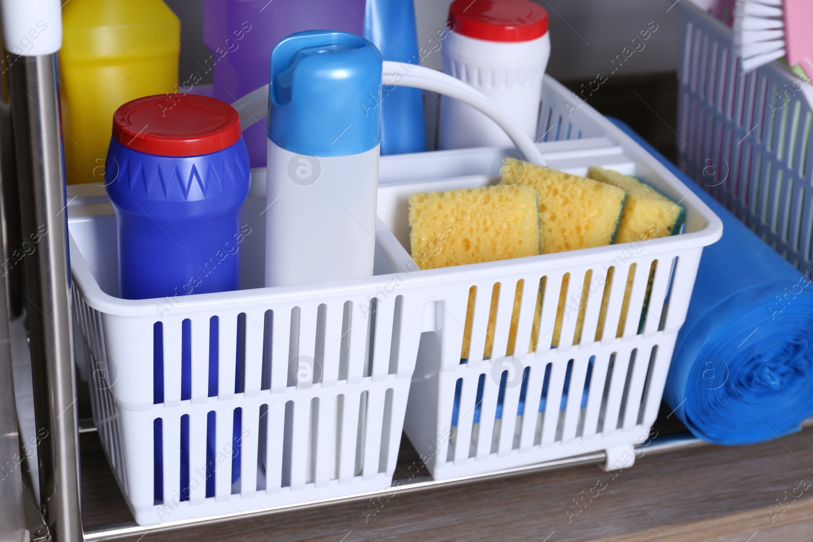 Photo of Different cleaning supplies in plastic boxes, closeup