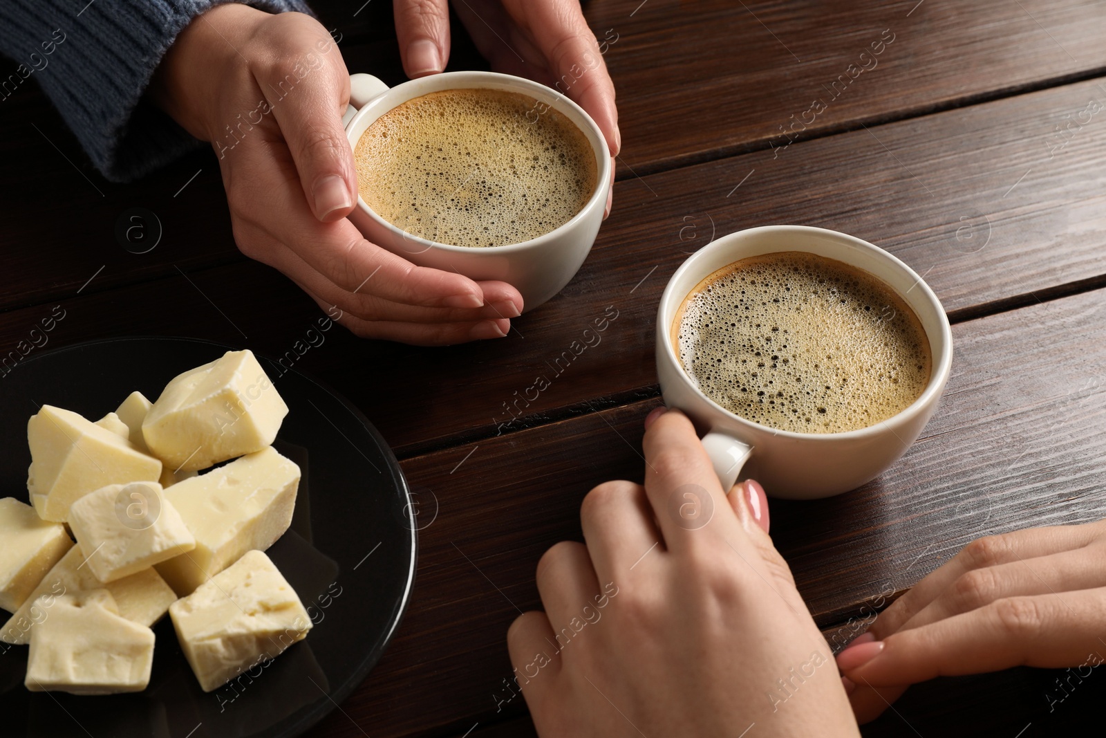 Photo of Women having coffee break at wooden table, closeup