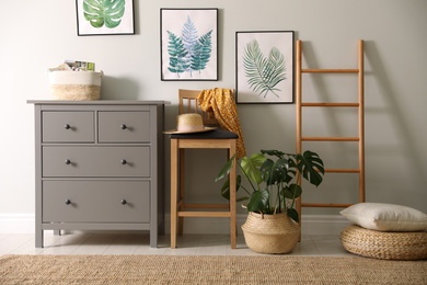 Stylish room interior with decorative ladder and monstera plant