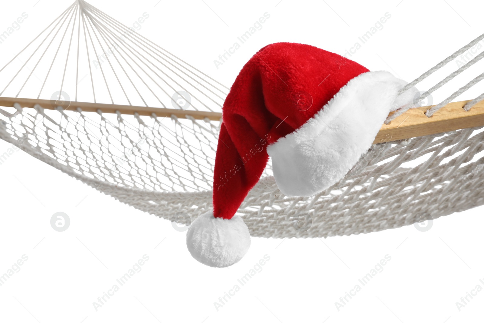 Photo of Comfortable hammock and Santa Claus hat on white background, closeup. Christmas vacation