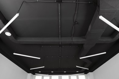 Black ceiling with lighting in office room