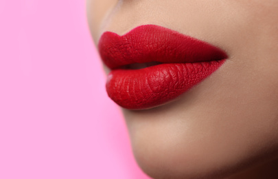 Photo of Woman with red lipstick on pink background, closeup