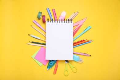 Photo of Flat lay composition with blank notebook and different school stationery on yellow background, space for text. Back to school