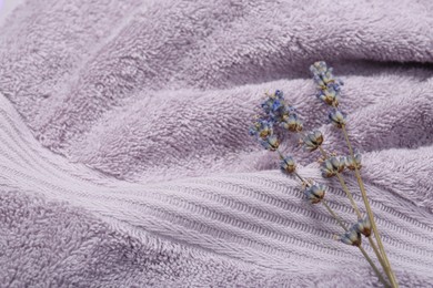 Photo of Lavender flowers on violet terry towel, closeup. Space for text