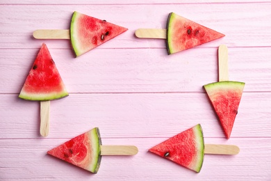 Frame made of watermelon popsicles on wooden background