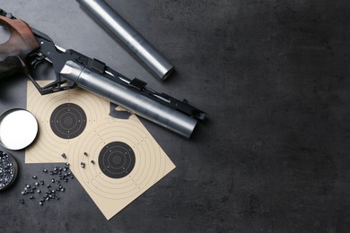 Photo of Flat lay composition with sport pistol on black table, space for text. Professional gun