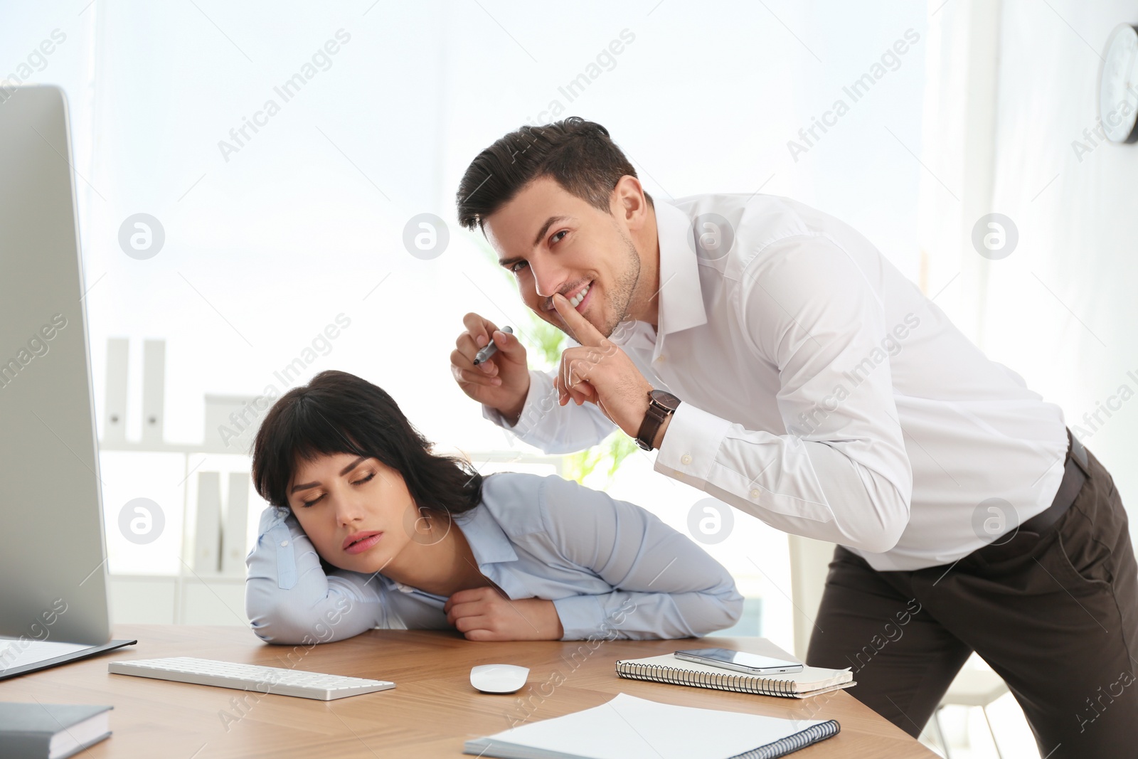 Photo of Man drawing on colleague's face while she sleeping at workplace. April fool's day