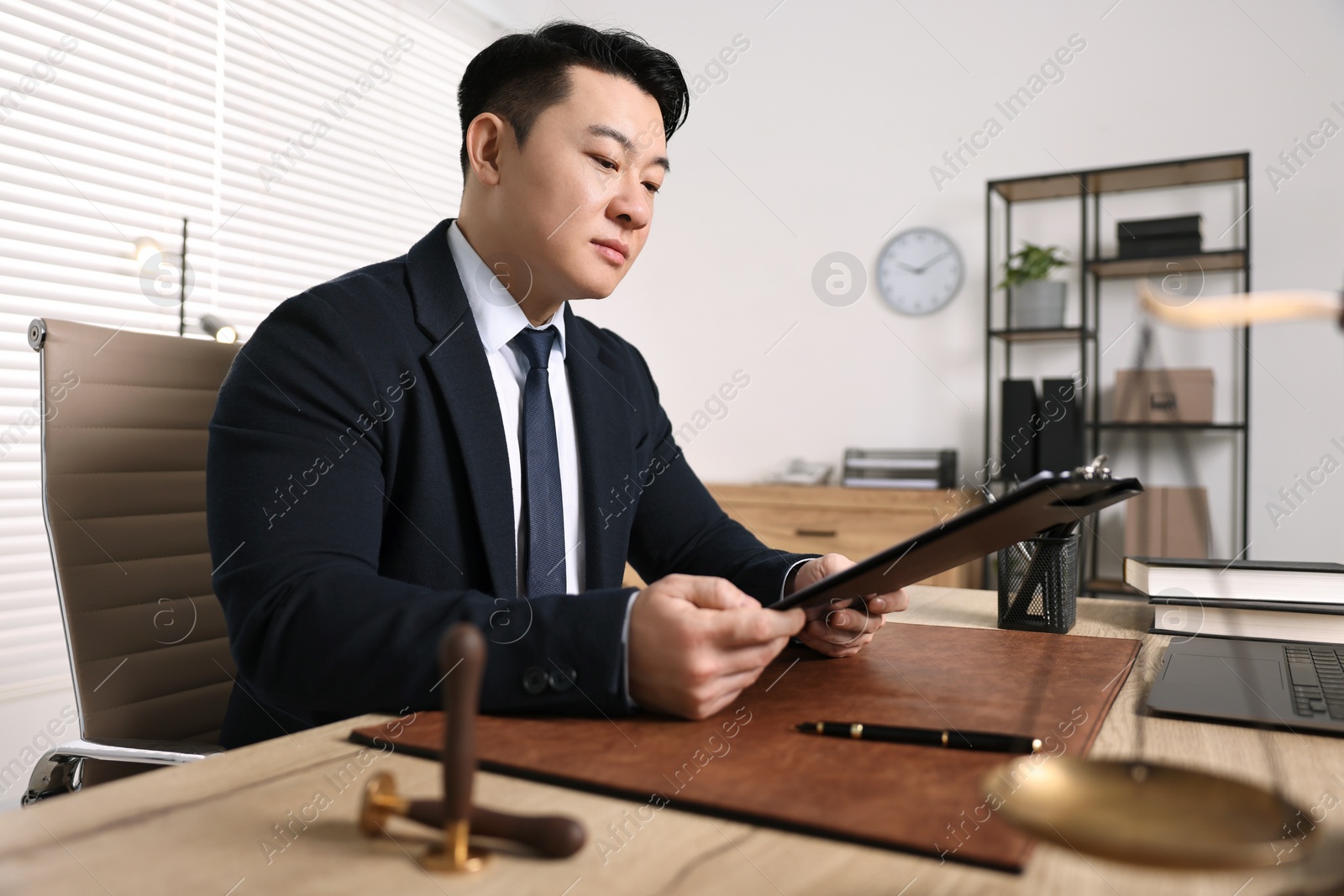 Photo of Notary working at wooden table in office