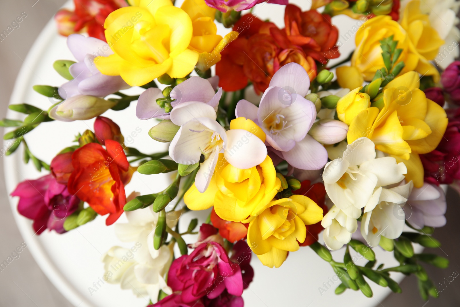 Photo of Bouquet of beautiful spring freesia flowers on table, closeup