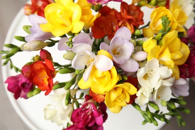 Bouquet of beautiful spring freesia flowers on table, closeup