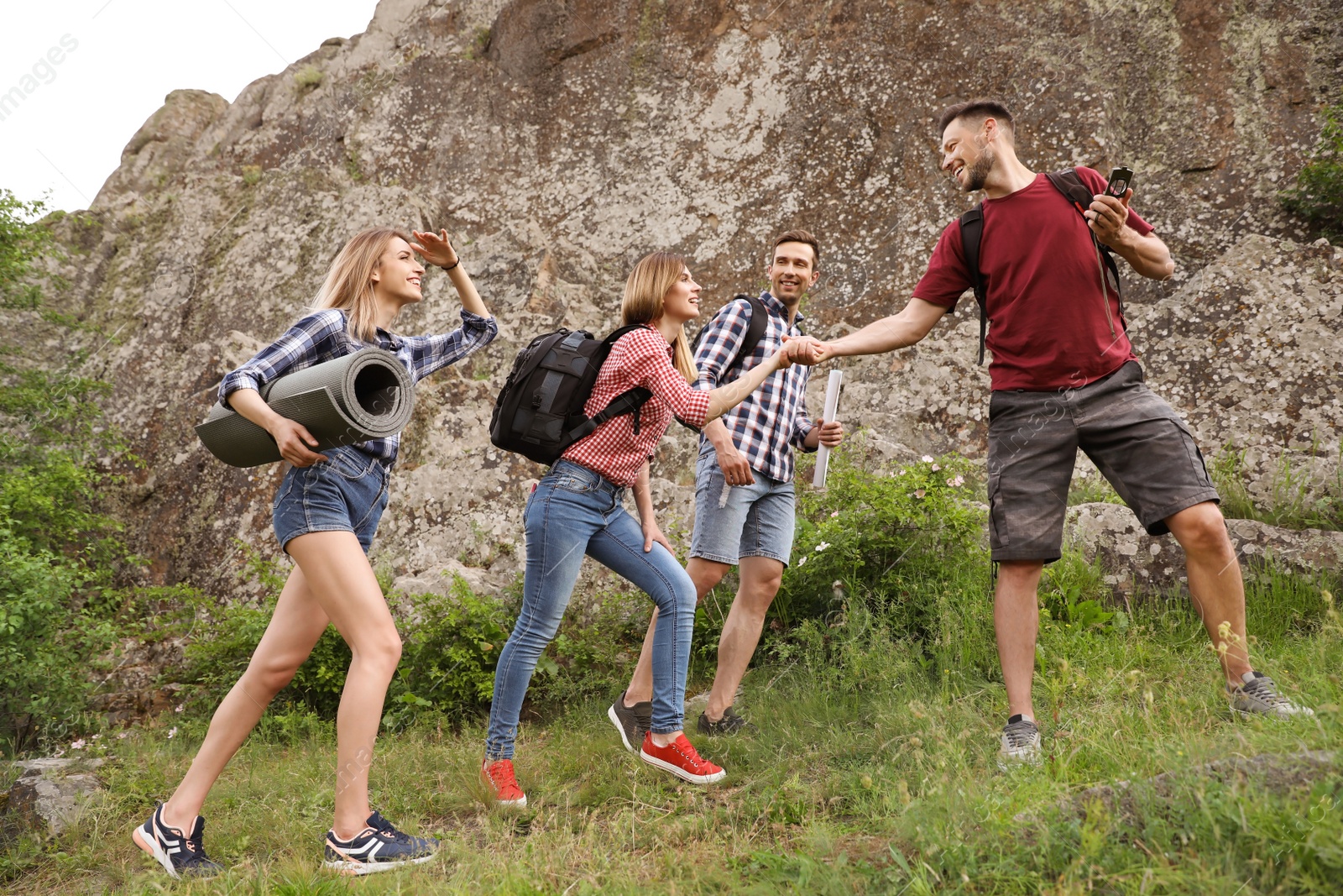 Photo of Group of young people hiking in wilderness. Camping season