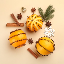 Flat lay composition with pomander balls made of fresh oranges on beige background