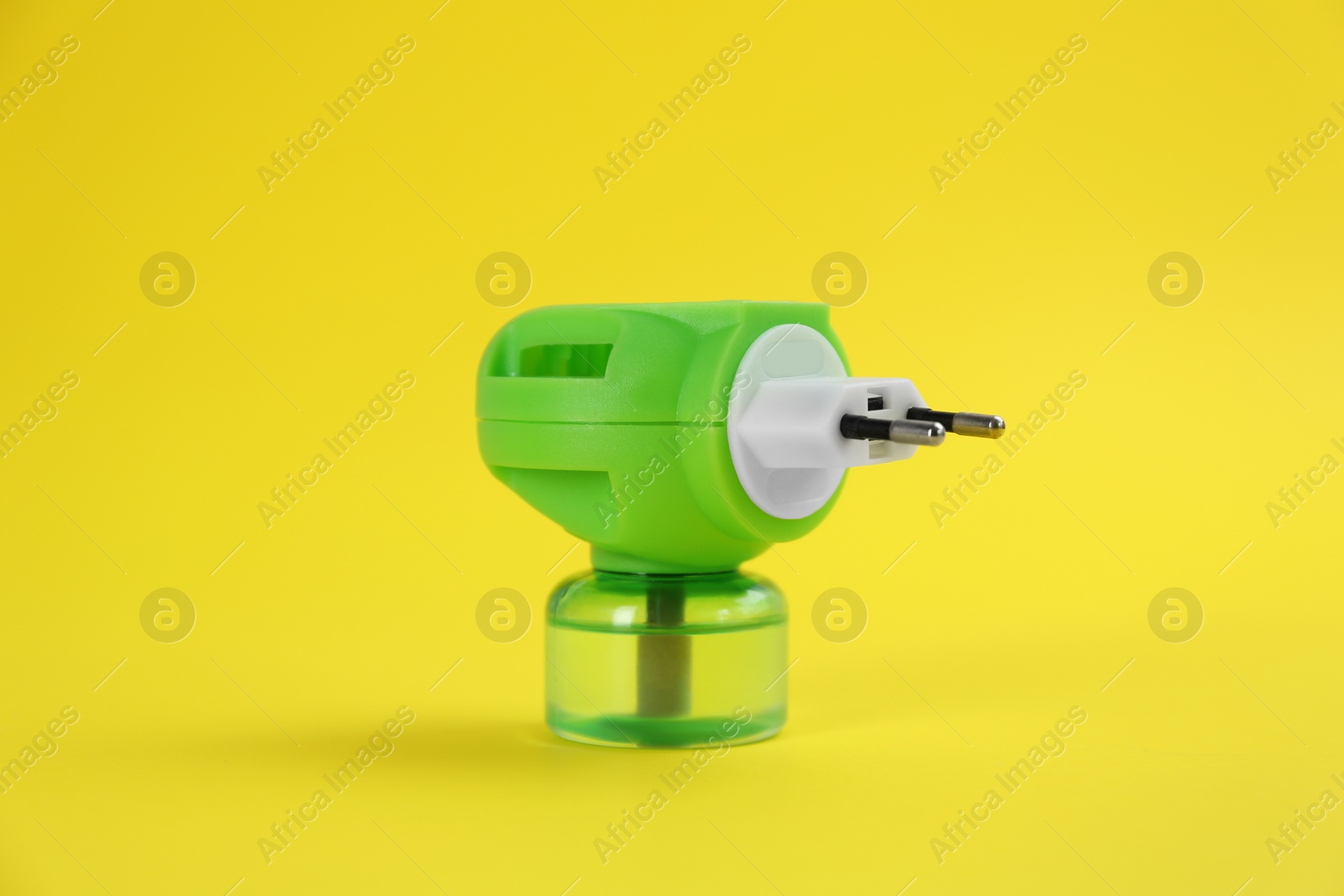 Photo of Electric vaporizer with insect repellent liquid on yellow background