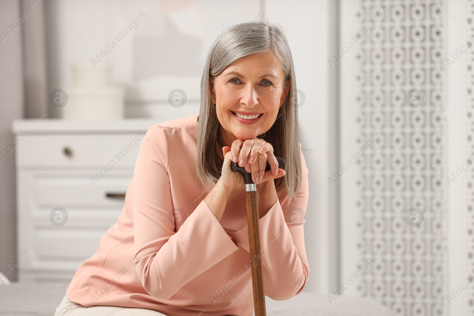 Photo of Mature woman with walking cane at home