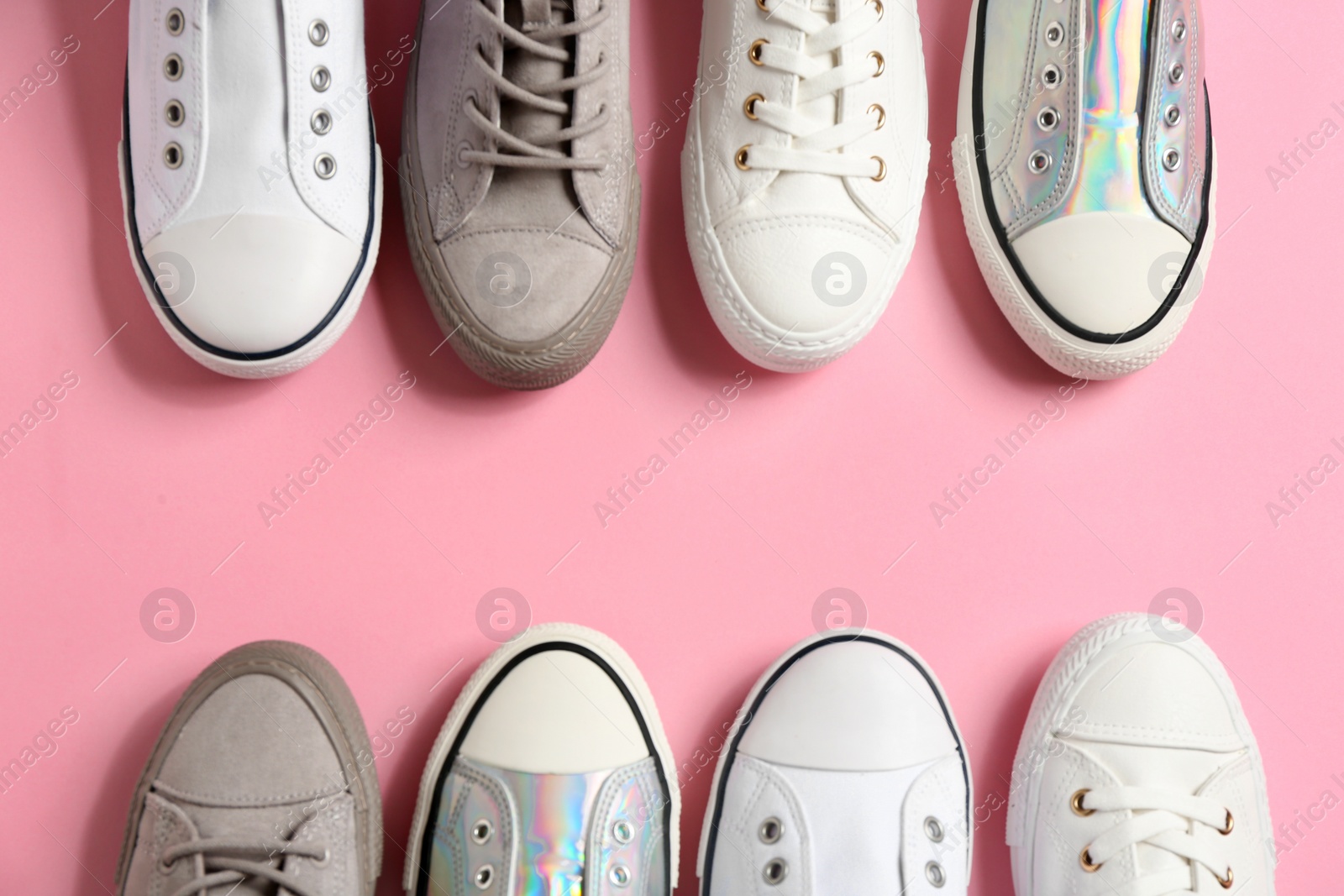 Photo of Flat lay composition with stylish sneakers on color background, space for text