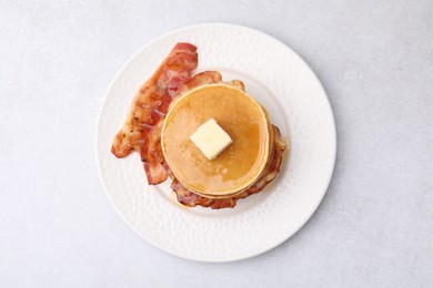 Photo of Delicious pancakes with bacon, butter and honey on light table, top view