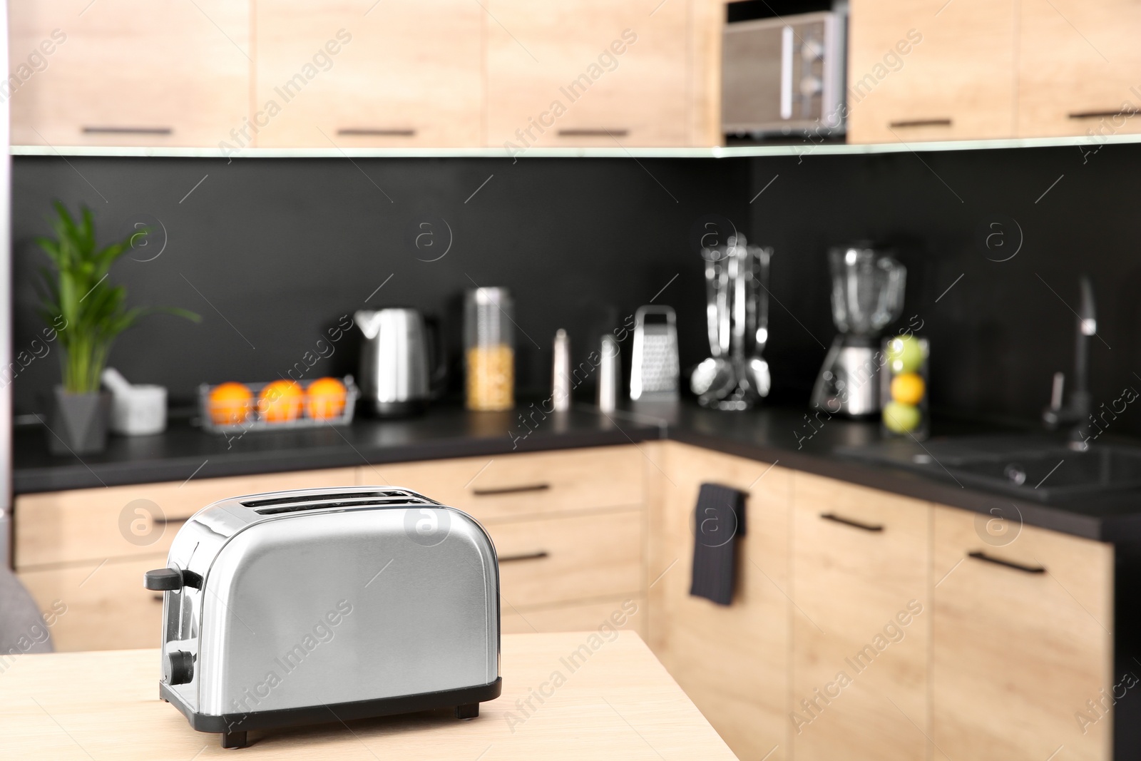 Photo of Modern toaster on table in kitchen, selective focus