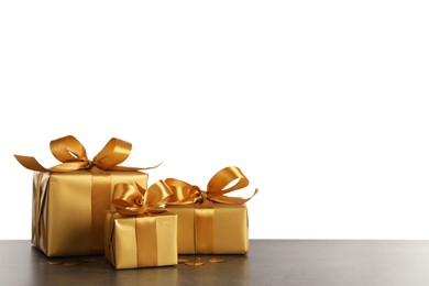 Photo of Three golden gift boxes on dark table. Space for text
