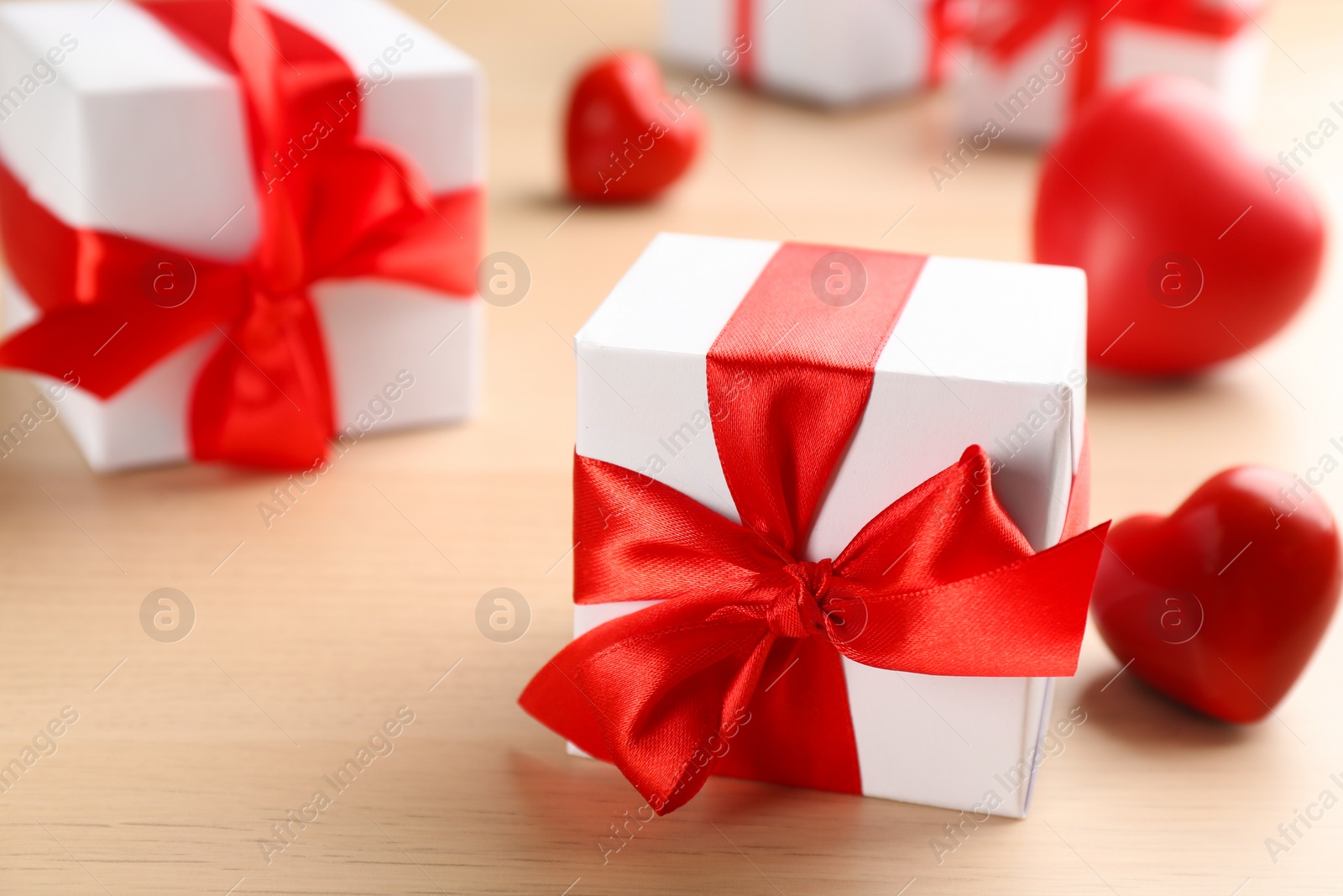 Photo of Beautiful gift boxes on wooden table, closeup. Valentine's Day celebration