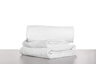 Photo of Soft terry towels on light table against white background
