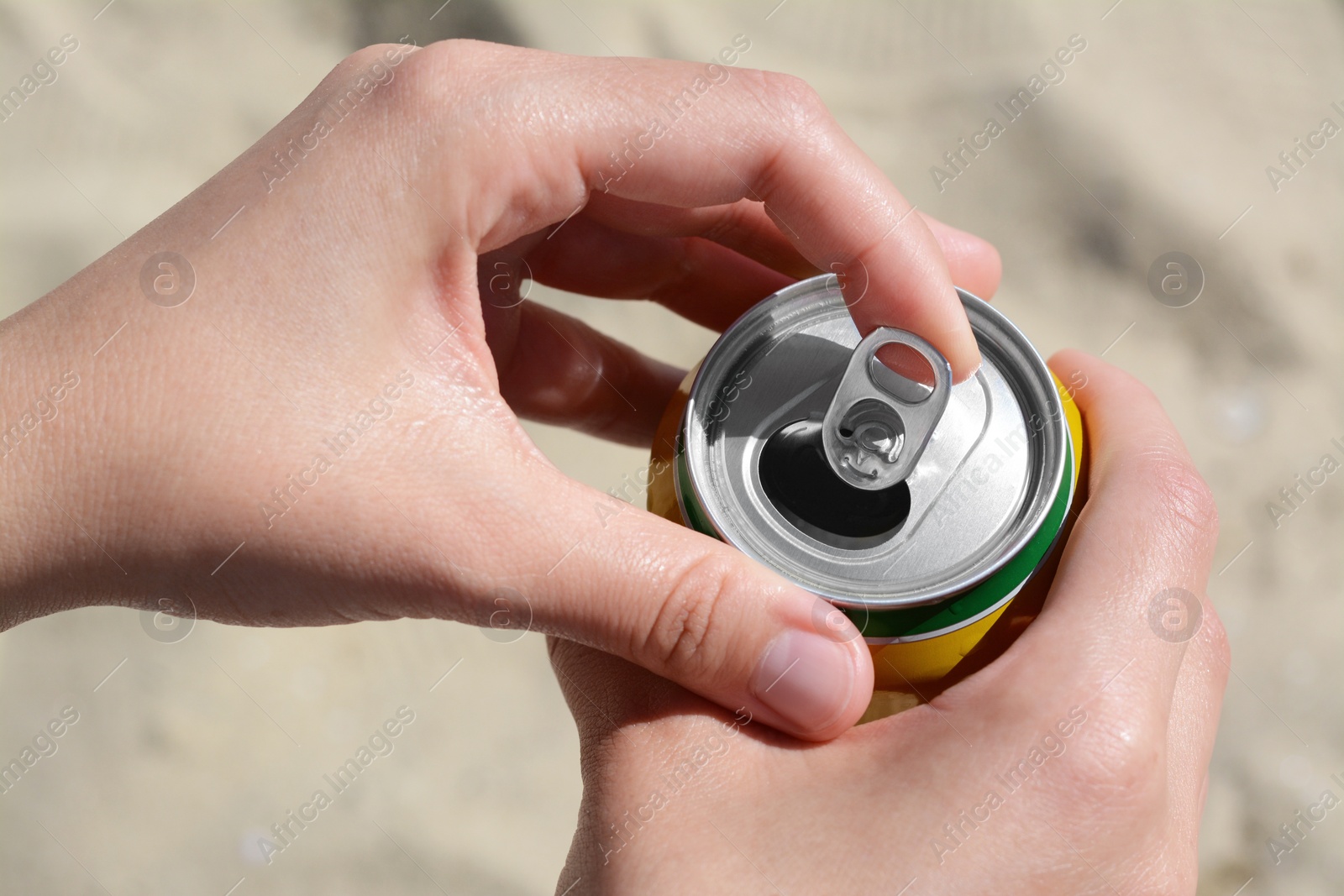 Photo of Woman opening can with sparkling drink at beach, closeup