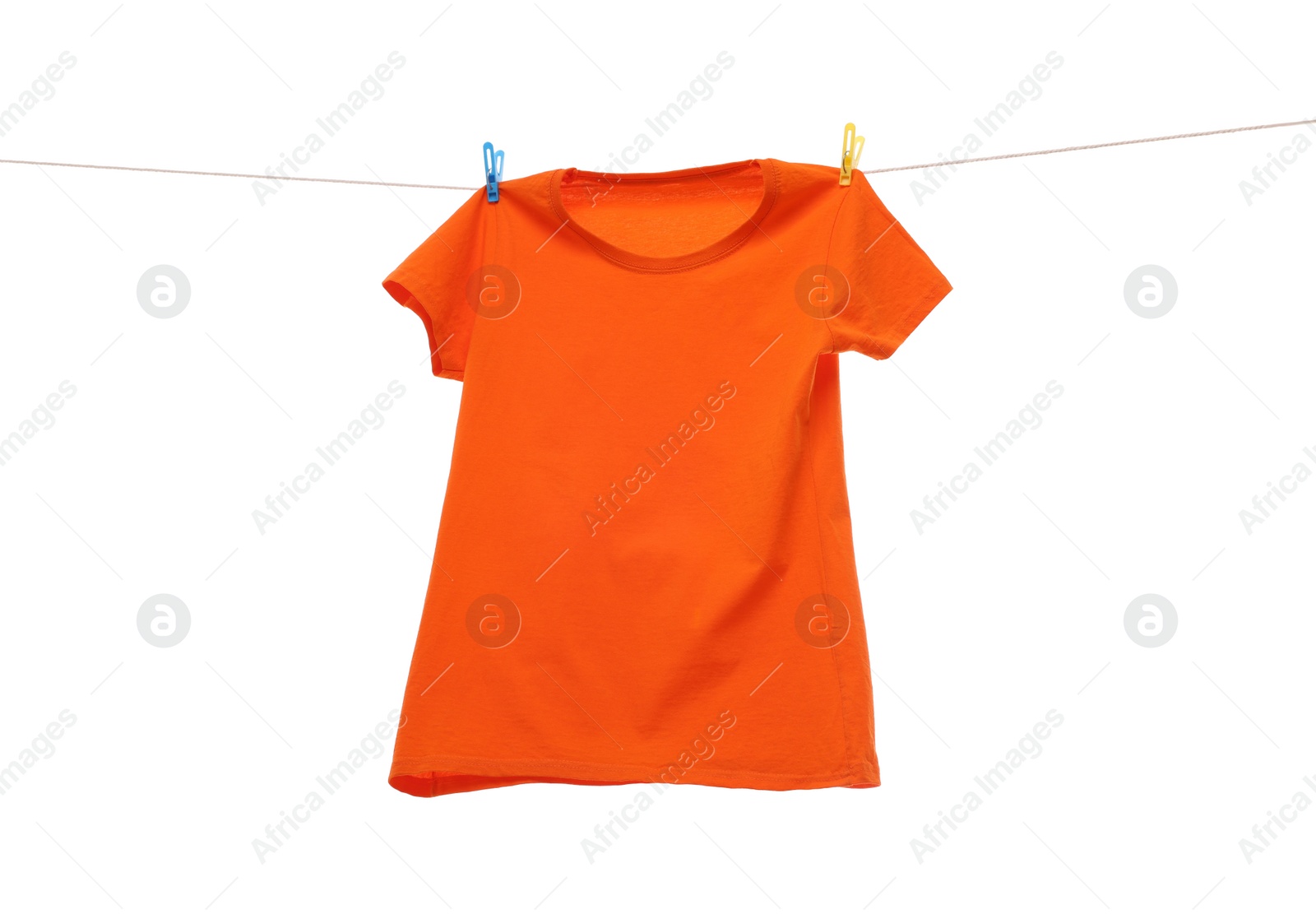 Photo of One orange t-shirt drying on washing line isolated on white