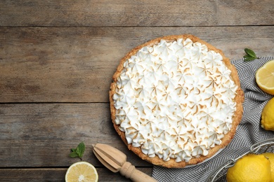 Flat lay composition with delicious lemon meringue pie on wooden table