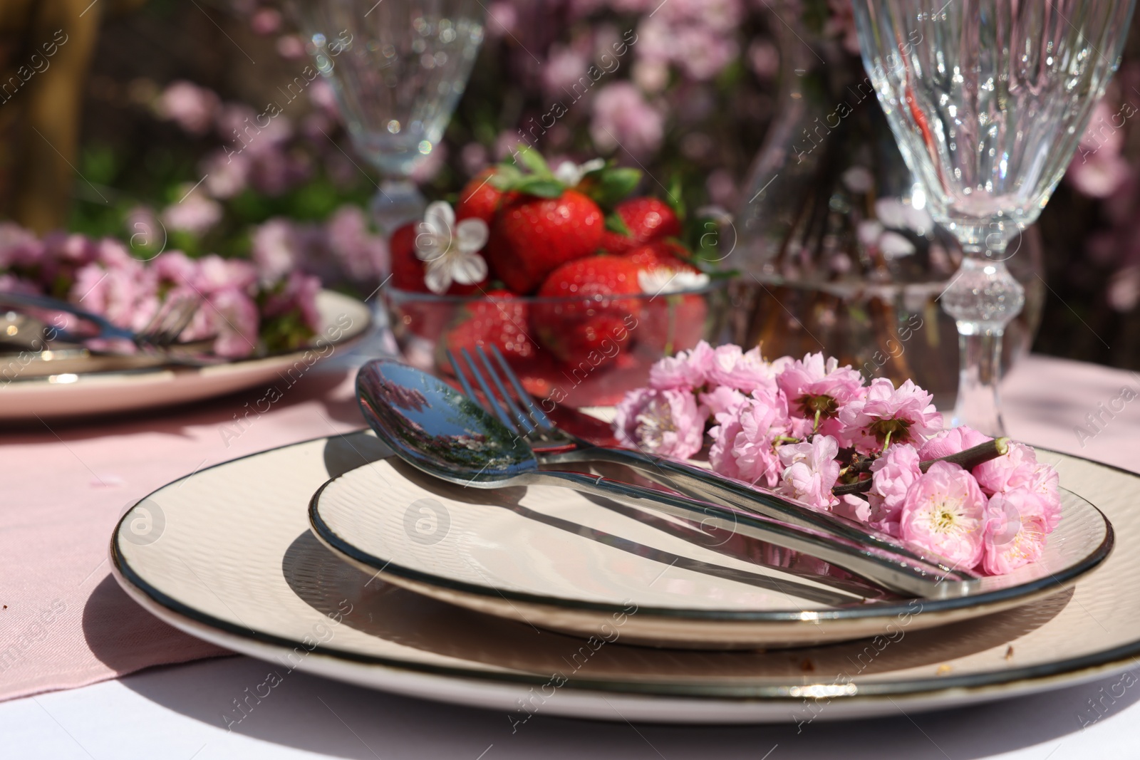 Photo of Stylish table setting with beautiful spring flowers in garden, closeup