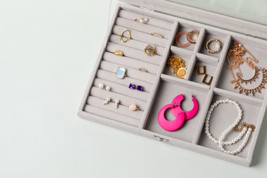 Jewelry box with many different accessories on light background, top view. Space for text